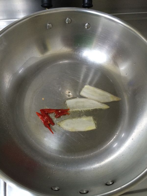 鍋中倒入一大匙油，熱鍋後將薑片與辣椒放入爆香。