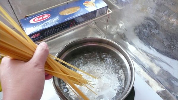 先煮一鍋熱水，加1小匙鹽，將半包的義大利麵放進去.