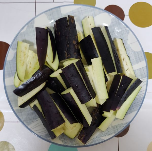 首先，先將茄子洗淨後，再切成段、切成條狀，此時也順便將蔥，切成蔥花，
這時燒一鍋水，待水滾後、再將茄子丟入川燙約1~2分鐘（免得過爛），且在川燙的過程中也將鍋蓋蓋好，免得茄子會變色。