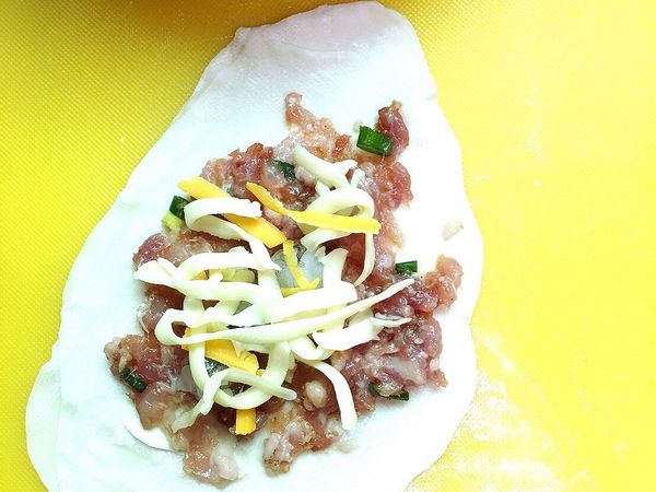 兩片水餃皮重疊後先鋪肉在放蝦仁塊最後放上起司條