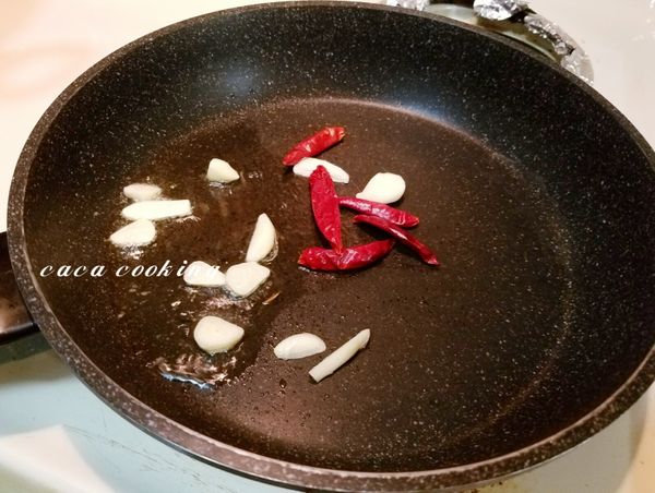 熱鍋加2匙的油，把蒜片及乾辣椒下鍋爆香。