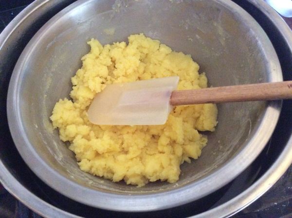 時間到，用刮刀不停的翻拌，直到刮刀上面不沾濕料，並且用刮刀壓下感覺有些硬度，即可熄火。奶黃餡即完成。放涼備用。