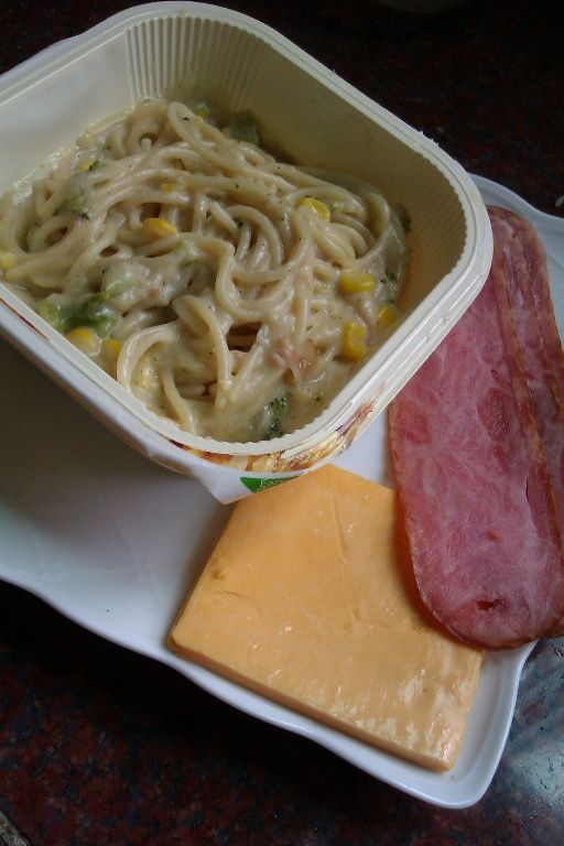 步驟1 將桂冠輕鬆生活奶油培根麵微波加熱，並將材料的培根煎好切段，把起司片切絲