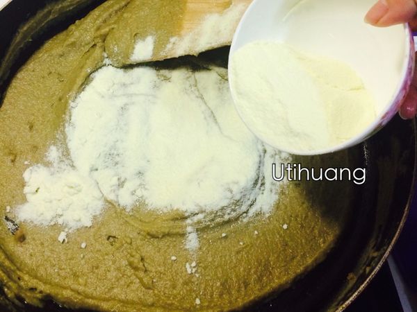 B材料 奶粉撒一半到已將奶油砂糖都吸收的綠豆泥，小火炒均勻邊收乾