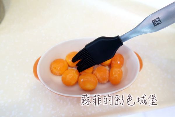 準備烏豆沙蛋黃餡：
均勻塗抹米酒在鹹蛋黃表面。