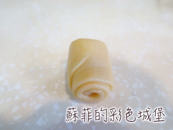 將麵糰桿成細長形後翻面,捲起成短圓柱體狀,蓋上保鮮膜，讓麵糰再靜置10~15分鐘。
