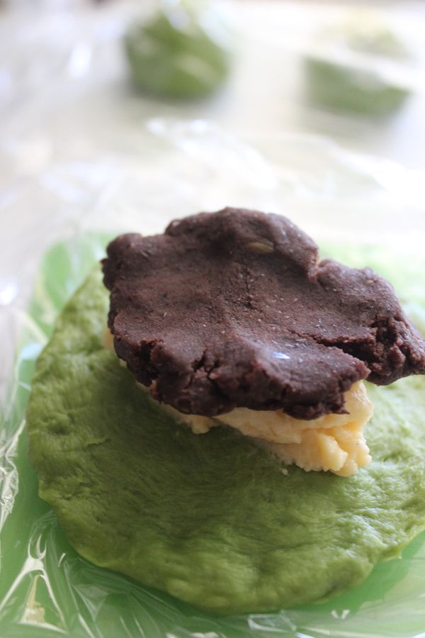 另一種包入紅豆25克與卡士達餡25克~麵團鋪平~依序放入卡士達與紅豆~手別沾到餡~麵團周圍也保持乾淨~將餡包入收口手緊收實~較不易載烘烤時爆餡~