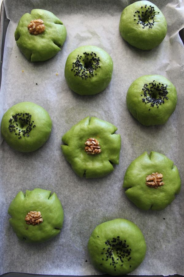 發酵好後~將單純包餡的麵包邊緣切五刀~表面放上核桃裝飾~我用蛋液做沾黏~包卡士達與紅豆餡的麵包~用手指沾些麵粉在麵包中間搓一個洞~再撒上黑芝麻(用蛋液做沾黏)入爐180度15分鐘