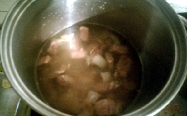 取一深鍋，將炒好的洋蔥和牛肉放入鍋中，再倒入可蓋過食材的水