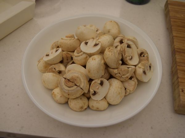 蘑菇去蒂，切半備用，蒜瓣去皮備用。