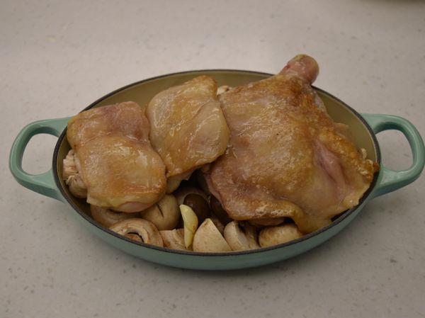 將雞腿排放到鋪好了蘑菇和栗子的烤盤上，烤箱預熱180度，蓋上蓋子或以鋁箔紙覆蓋起來，烤約20分鐘。（時間要依雞肉大小厚度調整）