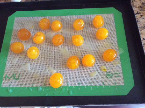 鹹蛋黃用水沖洗後瀝乾，排入烤盤，噴高濃度的白酒，325°F烤10分鐘。