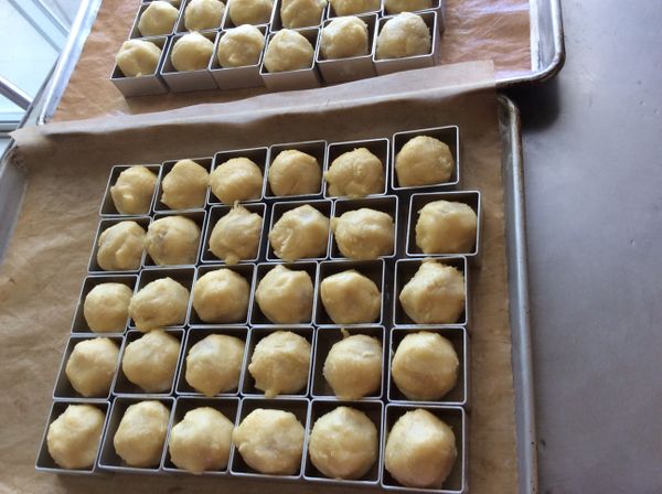 麵團包入餡料搓圓，放入模型中。