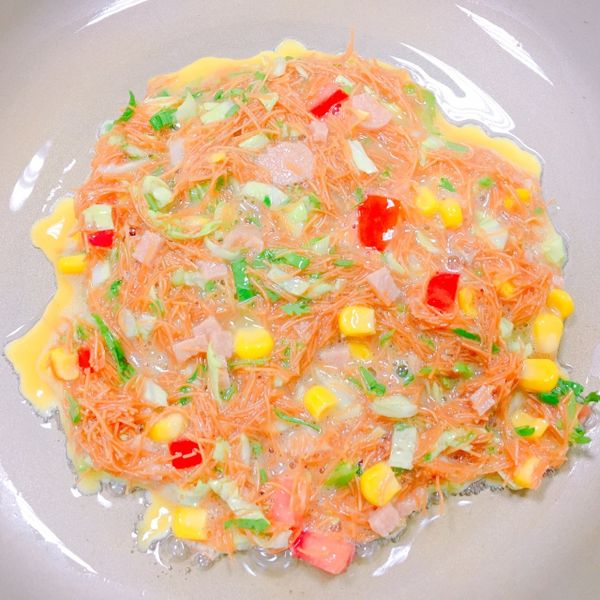 熱鍋,倒入適量的油,油熱,將食材倒入,鋪平,蛋凝固定型後,將其翻面,煎至兩面金黃