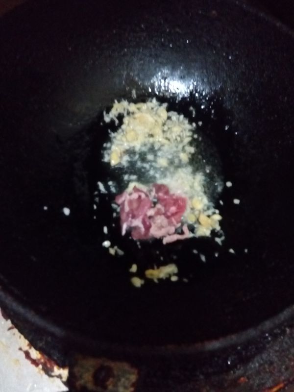 另起鍋放入沙拉油，加入蒜末，薑末，和肉絲。