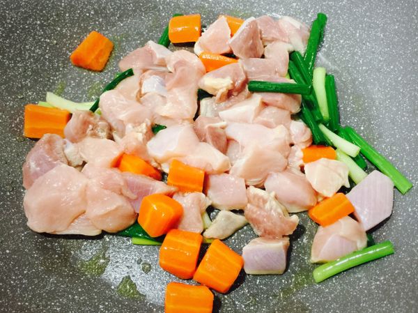 起油鍋，放入青蔥爆香，接著倒入紅蘿蔔，雞肉拌炒