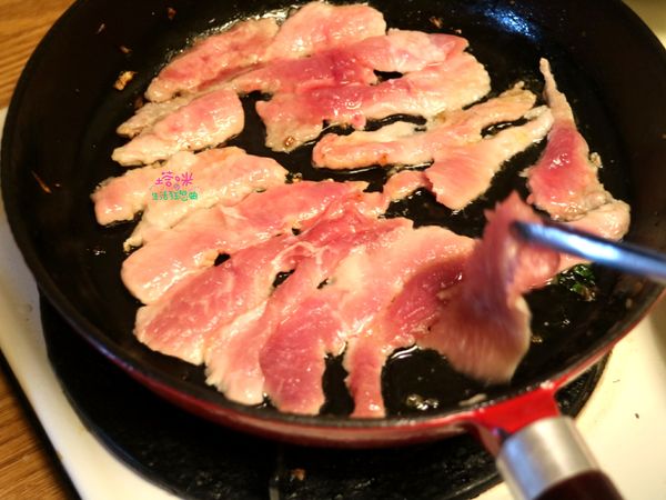視鍋中餘油狀況，可再添加少許油，將豬肉片鋪平放入鍋中，以中火香煎