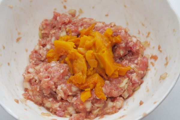 取一大容器，放入絞肉、洋蔥丁、南瓜和＜醃肉醬料＞抓拌均勻。