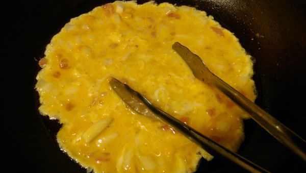 下鍋後，先用夾子不斷的攪動蛋液，不使它太凝固