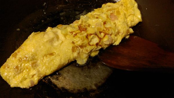 煎到底部熟透成型後，捲起成蛋捲形狀