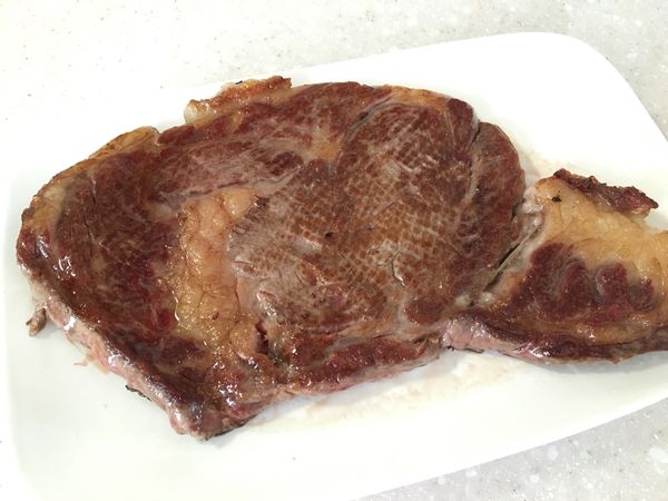 鐵板放置瓦爐爐上空燒到很熱，牛排放進鐵盤後，每幾秒就翻面一次，直到兩面赤赤(今天牛排中心溫度52度)。