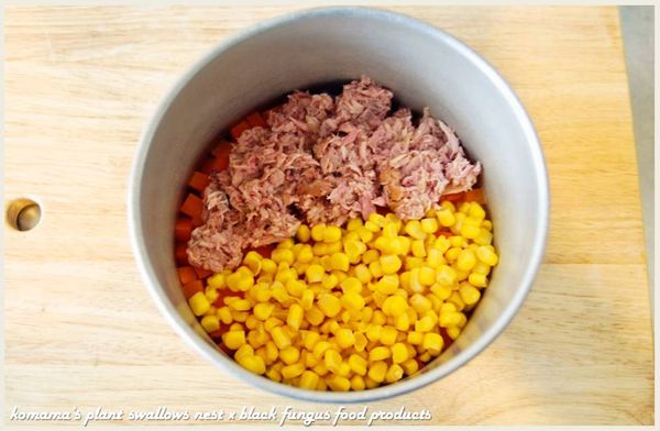 在煮熟後的飯中，陸續放入玉米粒與鮪魚肉，並倒入些許罐頭內的湯汁。