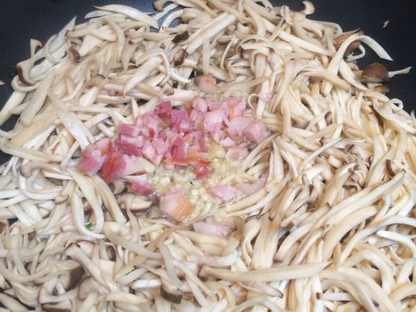 撥出鍋內中間空位, 加入蒜末和培根丁拌炒