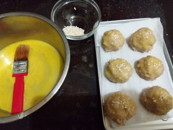 上面沾蛋黃液，灑上白芝麻。