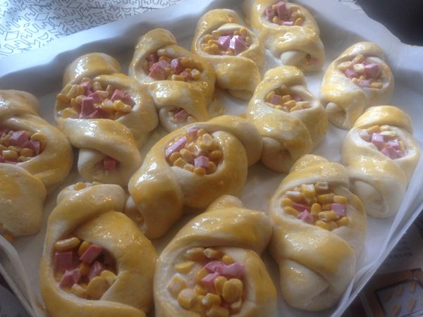 一個一個放在有烤盤紙的烤盤上，等待二次發酵，大約半個小時麵團會發到適量的大小如圖，此時刷上蛋黃，然後送進已經預熱好的烤箱200度，中下層，25分鐘左右，只到麵包表面金黃，香味四溢，就可以了。