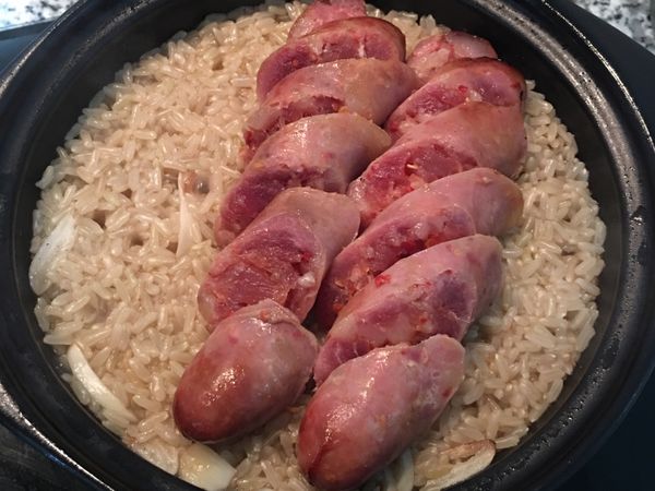 15分鐘後，可以看到本來淹過米的水已經看不到了，這時再將香腸鋪在米上續煮10分鐘。