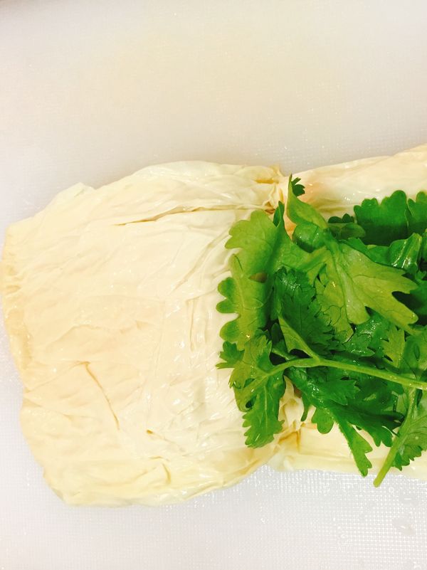 豆皮翻開，放入香菜葉子，灑一點胡椒鹽。