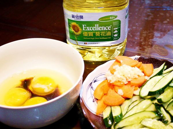 小黃瓜洗淨切去蒂頭後先直切對半再切片，紅蘿蔔去皮後一樣先直切對半後再切片，

  蒜頭洗淨去皮切碎，蛋打入碗中，加入1小匙醬油後打成蛋液備用。