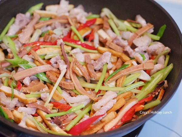 改大火，炒至豆干變金黃色時，下蒜苗白、魷魚、辣椒、芹菜和下五香粉1/4匙、白胡椒粉1/4匙拌炒。