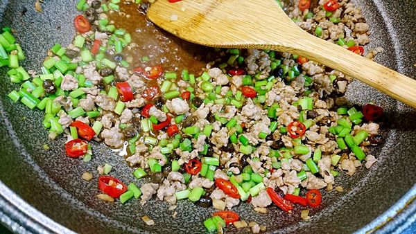 把剛剛的豆豉水也下下去，記得控制量，讓底部有濕度即可。這時把火轉成大火，下少許雞粉、糖。