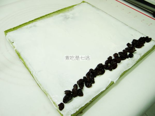 在蛋糕片上均勻的抹上內餡(要用葡萄乾的時候，用蘭姆酒泡軟再捏乾使用)，尾端不要抹太厚，第一次提起時，往前壓，稍為停頓一下，等定型，再往前捲