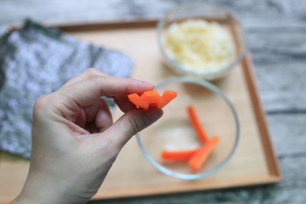 把半圓柱體的紅蘿蔔切成像W形的模樣。(如照片，燙熟後變軟比較好切。)