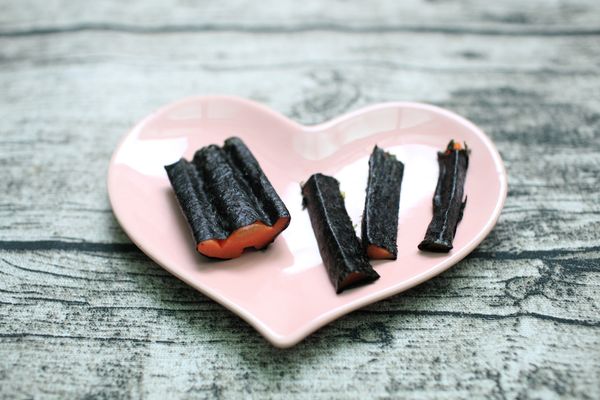 剪數塊海苔把每塊紅蘿蔔都包起來。