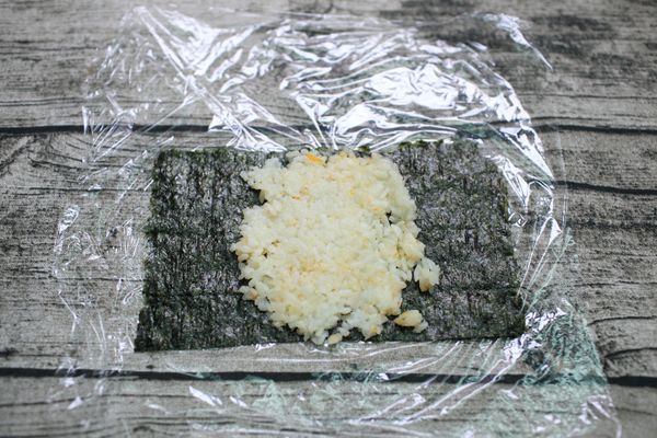 在海苔中段(中間2/4左右的長度)鋪上一層薄薄的飯壓實。