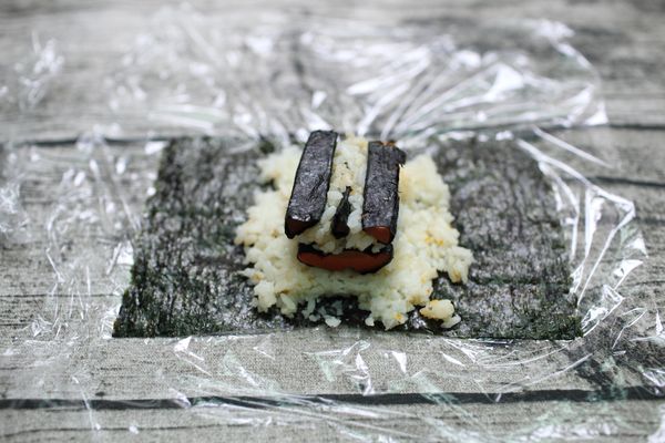 再放上三角形紅蘿蔔在(半圓形中心點的上方)鋪上一點飯後放上剩下的兩個三角形紅蘿蔔。