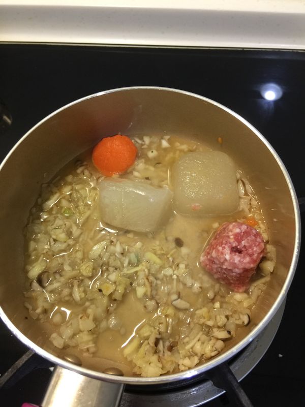 炒出香菇香氣後放入高湯、豬絞肉、紅蘿蔔泥煮滾