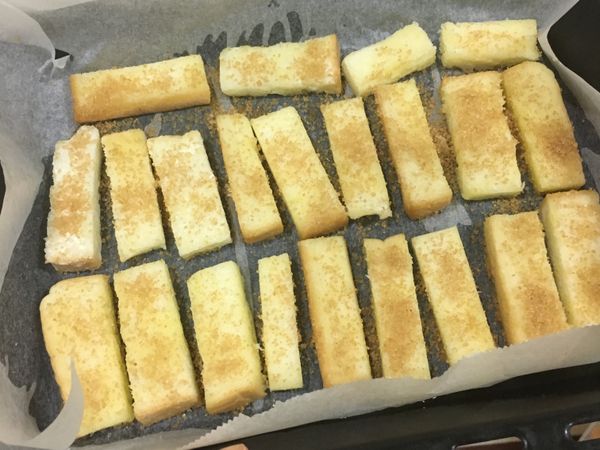 將塗好奶油的吐司條，沾上或灑上調好的焦糖肉桂粉