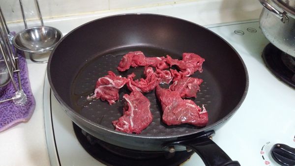 在鍋中加入香油及食用油爆炒牛肉片