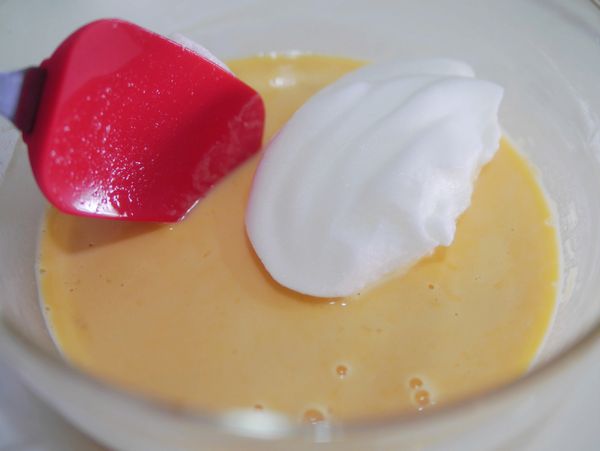 加入1/3打發的蛋白，用矽膠刮刀輕輕混合後(物大力腳打會消泡)，再分次加入拌成均勻的麵糊。