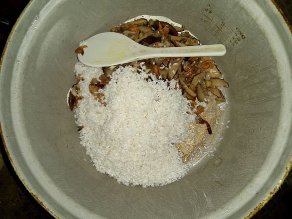 加入泡好1天長糯米，加入曾在鍋放油爆香紅蔥頭，蝦米，泡水後乾香菇切片一起炒好的。一起拌勻。