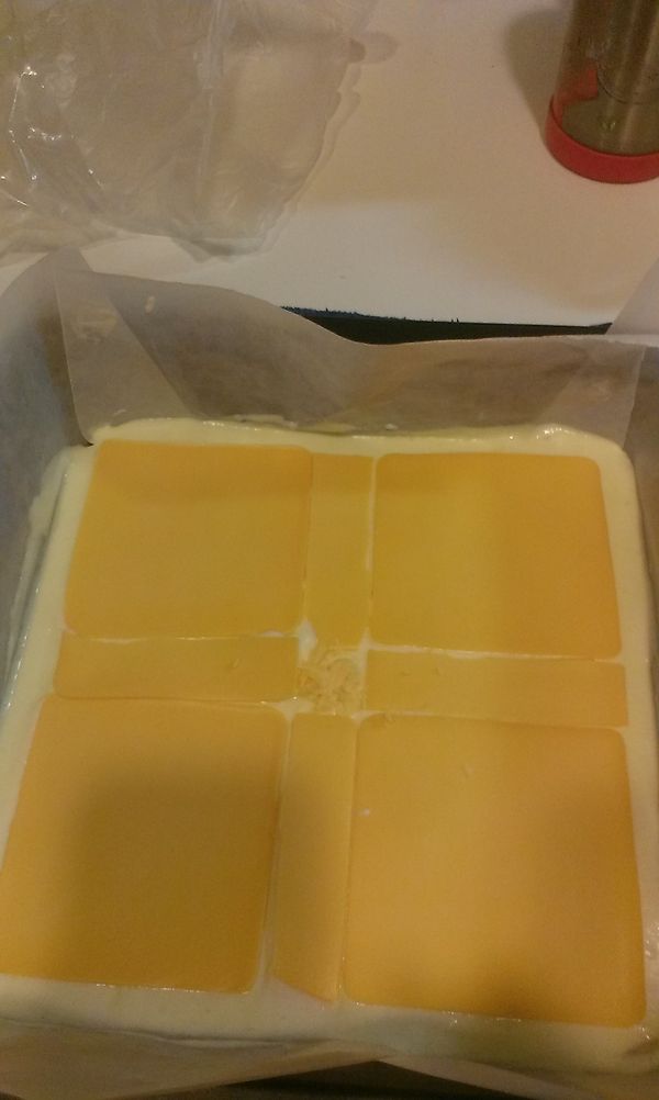 將拌好麵糊到一半入模具鋪平再.鋪上起士片後再入另一半麵糊
鋪平敲幾下隔水入烤箱