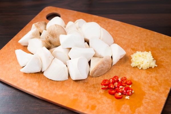 以微濕的廚紙抹乾淨杏鮑菇後切塊，把紅辣椒去頭切圈，把蒜頭去衣剁成蓉。