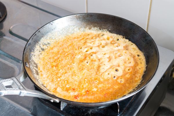 下鹹蛋黃、紅辣椒和蒜頭炒至起泡。