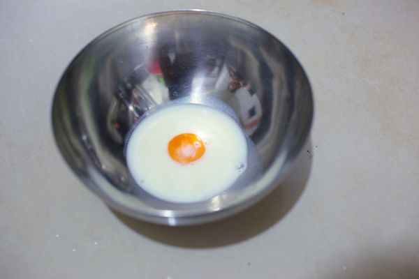 把蛋黃和配方奶(奶粉+水用冷開水沖)倒入盆中。
