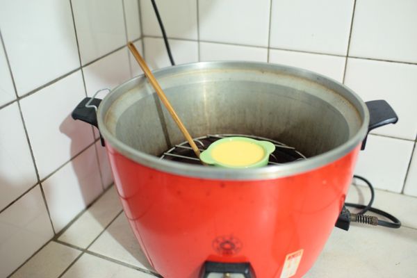 將裝布丁液的容器輕輕放入電鍋，並插一枝筷子。