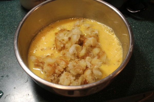 打好四顆蛋，馬鈴薯趁熱倒入蛋液中，快速拌勻，讓餘熱將蛋液變成半熟狀。